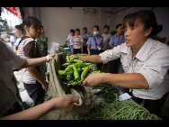 Local residents buy vegetables at a temporary open market in front of the county government building in Zhouqu, Aug 14, 2010. [Xinhua]