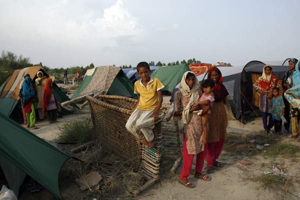 Flood victims are seen at the Sultan Colony, an internally displaced persons camp, in Pakistan&apos;s province of Punjab, near the city of Multan, August 15, 2010. Swollen by torrential monsoon rains, major rivers have flooded Pakistan&apos;s mountain valleys and fertile plains, killing up to 1,600 people and leaving two million homeless. .[Xinhua/Reuters]