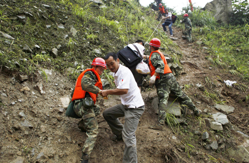 Rescuers help evacuate people trapped by landslides in Yingxiu town, Southwest China&apos;s Sichuan province on August 17, 2010. Landslides have driven locals to leave their homes for other cities in Sichuan such as Dujiangyan and Chengdu. The massive mudslide that hit the region on Saturday had killed 15 people and injured nine others by Monday, local authorities said Tuesday.[Xinhua] 