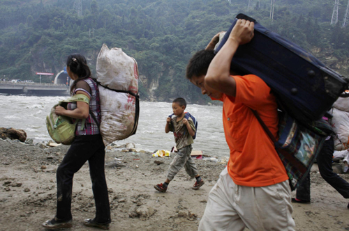 People leave their hometown at the upper side of a barrier lake in Yingxiu town, Southwest China&apos;s Sichuan province on August 17, 2010. [Xinhua] 