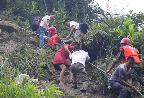 Rescuers help evacuate people trapped by landslides in Yingxiu town, Southwest China&apos;s Sichuan province on August 17, 2010. [Xinhua]