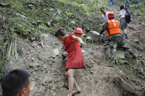 Rescuers help evacuate people trapped by landslides in Yingxiu town, Southwest China&apos;s Sichuan province on August 17, 2010. [Xinhua] 