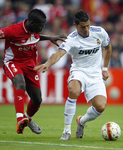 Real Madrid's Cristiano Ronaldo evades Standard Liege's Daniel Opare (L) during their friendly soccer match at the Maurice Dufrasne stadium in Liege August 17, 2010. (Xinhua/Reuters Photo) 