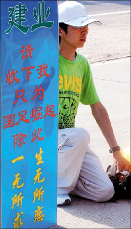 Zhou Peng kneels outside Jianye football club holding a placard saying ‘Please hire me, I want to save the nation's soccer