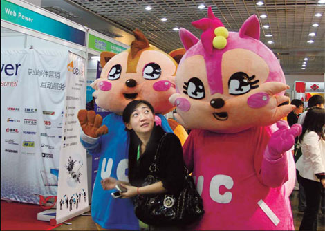A woman looks at UC browser's mascots at the China Internet Conference 2010 in Beijing. [China Daily]
