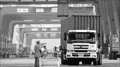 Containers are loaded on a cargo ship for export at the port of Tianjin. China has become a major manufacturing center for many multinational firms.[China Daily]