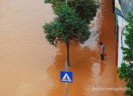 A man stands on a flooded street in Kunming, capital of Yunnan province, Aug 15, 2010.