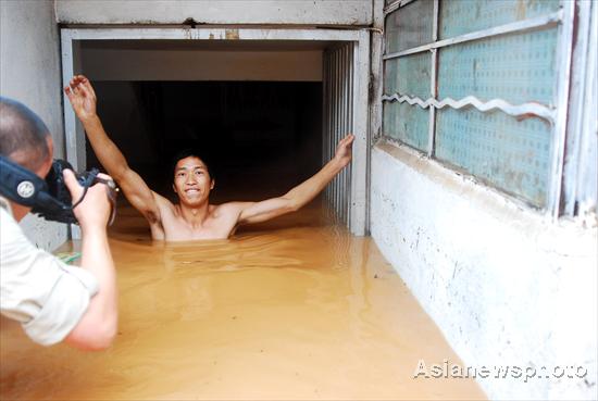 A man walks through the floodwater in Kunming, capital of Yunnan province, Aug 15, 2010.