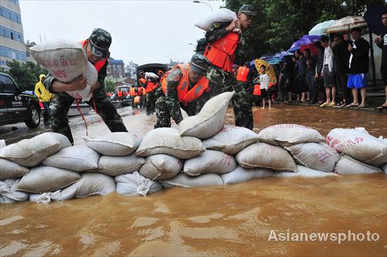 Paramilitary police pile up sandbags to block the floodwater in Kunming, capital of Yunnan province, Aug 15, 2010.