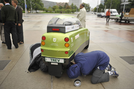 A father and son from Australia check their electric vehicle, called Trev, before the global tour starts on August 16, 2010. 