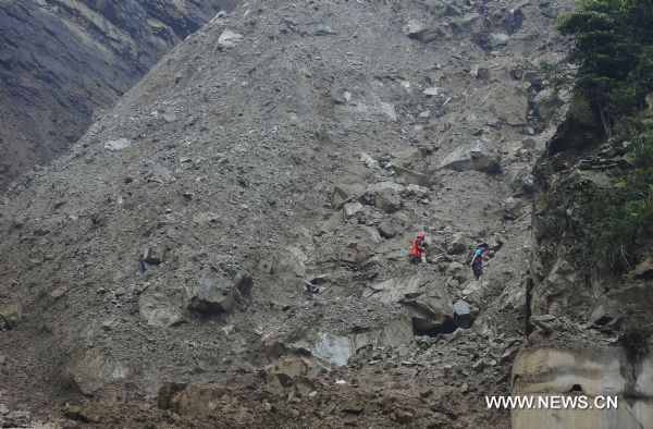 People walk down a slope under the help of soldiers as they evacuate to safe place in Yongxiu Town, Wenchuan County, southwest China's Sichuan Province, Aug. 17, 2010.