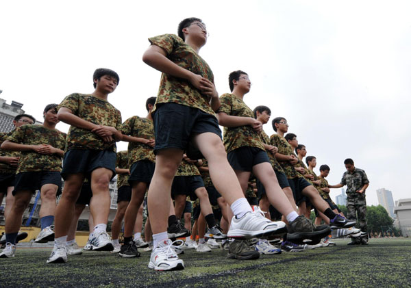 An instructor checks parade steps of high school students in Nanjing on Aug 17. Several senior high schools in Nanjing, East China&apos;s Jiangsu province are conducting a one-week military training course for freshmen, to help them prepare for future study and life. [Xinhua] 