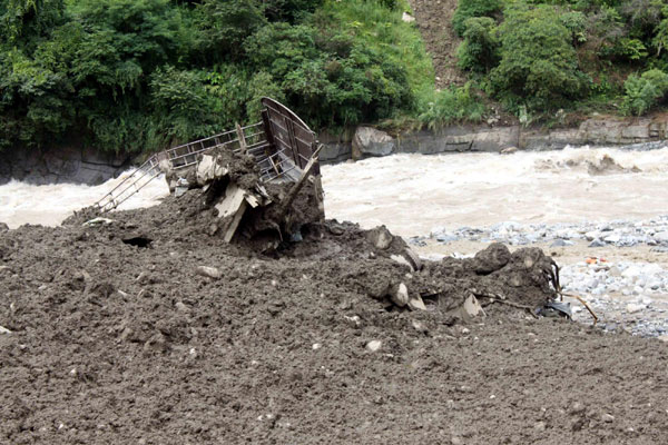 A truck is buried in the mud after a landslide in Yunnan on August 18, 2010. A rain-triggered mudslide slammed Puladi Township in Southwest China&apos;s Yunnan province about 1:30 am on Wednesday, leaving at least one people dead and 90 others missing. Roads, power supplies and telecommunications were cut off in the remote town. A bridge and parts of roads were destroyed. Rescue soldiers have been sent to the area, the Yunnan Provincial Emergency Response Office said. [Xinhua] 