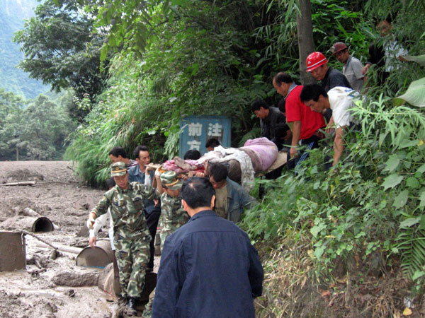 Soldiers take injured people out of the mudslide in Yunnan on Aug 18.[Xinhua]