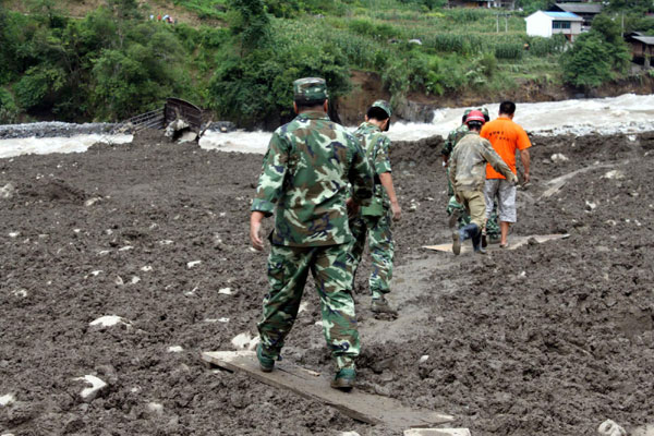 Soldiers rush to the scene after a mudslide in Yunnan on Aug 18.[Xinhua]