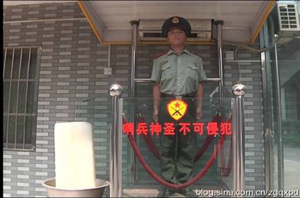 A sentinel stands guard in sweltering heat, with a big block of ice beside him to help keep cool. [Blog.sina.com.cn]