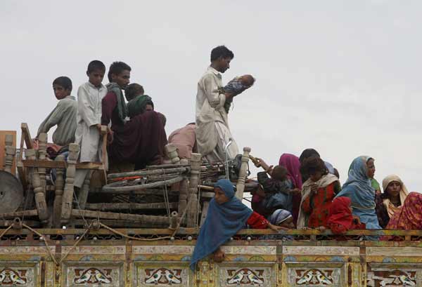 Members of a family fleeing flood waters board a truck while looking for higher grounds in Sukkur in Pakistan's Sindh province August 16, 2010. Pakistan authorities forecast on Monday a brief respite in rains that sparked the country's worst floods in decades, but aid agencies warned help was too slow to arrive for millions without clean water, food and homes. [Xinhua]