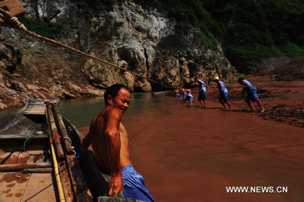 Boat trackers tow the wooden boat forward in Shennongxi Canyon, a famous tourist resort of the Three Gorges scenic area, in Badong County, central China's Hubei Province, Aug. 17, 2010. Over 700 boat trackers are working in the canyon at present to showcase the time-honored boat-tracker culture. [Xinhua/Zhang Xiaofeng] 