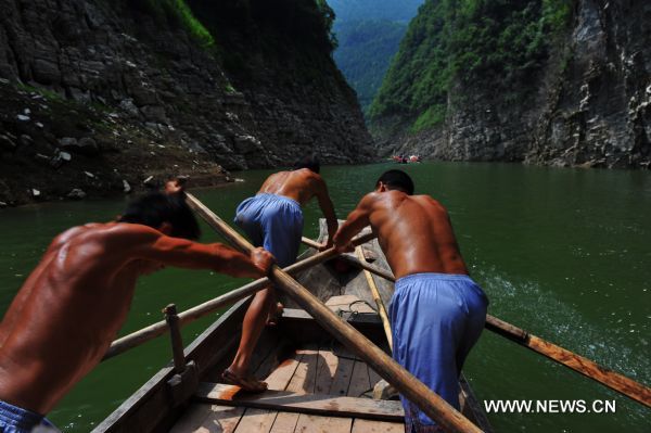 Boat trackers oar their way in Shennongxi Canyon, a famous tourist resort of the Three Gorges scenic area, in Badong County, central China's Hubei Province, Aug. 17, 2010. Over 700 boat trackers are working in the canyon at present to showcase the time-honored boat-tracker culture. [Xinhua/Zhang Xiaofeng]