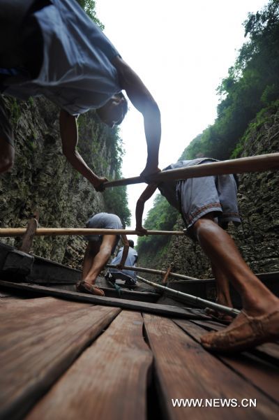  The file photo taken in August 2009 shows boat trackers oaring their way in Shennongxi Canyon, a famous tourist resort of the Three Gorges scenic area, in Badong County, central China's Hubei Province. Over 700 boat trackers are working in the canyon at present to showcase the time-honored boat-tracker culture. [Xinhua/Zhang Xiaofeng]