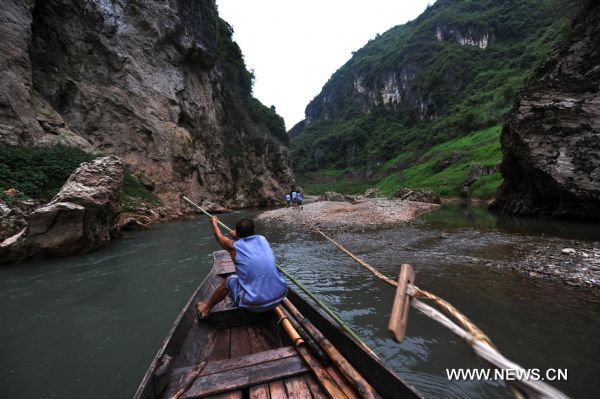 The file photo taken in August 2009 shows a boat tracker propelling a boat with scull in Shennongxi Canyon, a famous tourist resort of the Three Gorges scenic area, in Badong County, central China's Hubei Province. Over 700 boat trackers are working in the canyon at present to showcase the time-honored boat-tracker culture. [Xinhua/Zhang Xiaofeng]