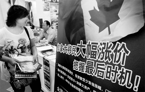 A woman passes a Canadian real estate agent's advertisement at a Beijing property fair in June targeting 'investor immigrants' to Canada. [China Daily]