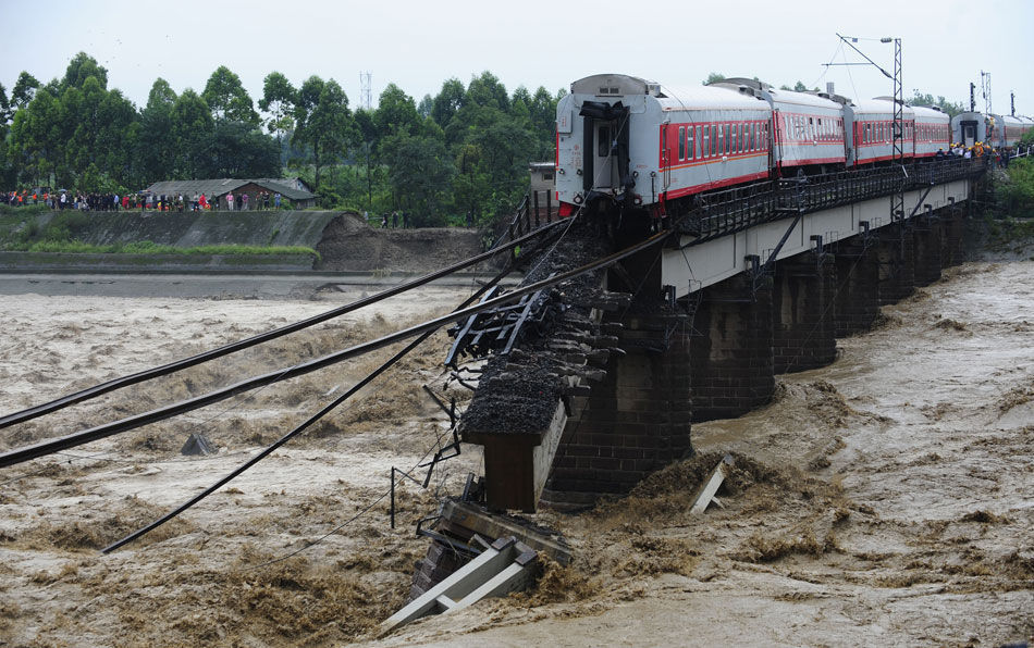 Two train carriages plunged into a river after floods destroyed a bridge section of a railway line in southwest China's Sichuan Province Thursday. 