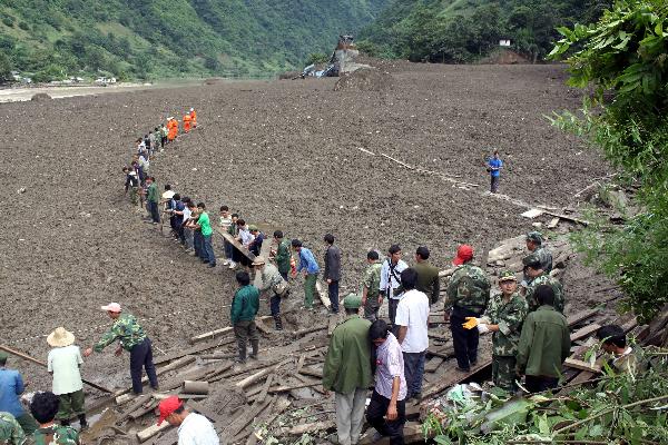 Rescuers and residents carry out the rescue work in mudslides-hit Puladi Township of Gongshan Drung-Nu Autonomous County, southwest China's Yunnan Province, Aug. 18, 2010. Rain-triggered mudslides occurred here on early Wednesday, causing at least 67 people missing.