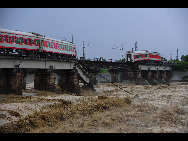 Two carriages of a passenger train fell into a river after floods destroyed a bridge in Guanghan, Sichuan province, August 19, 2010. The accident happened at about 3:20 pm Thursday and the two fallen carriages, part of the K156 train from Xi'an to Kunming, were swept 200 meters downstream. All the passengers were evacuated and no casualties have been reported so far.[Xinhua]