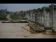 The fallen carriages are seen lying in the flooded river in Guanghan, Sichuan province, August 19, 2010. [Xinhua]