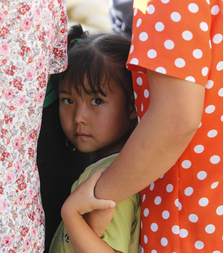 A girl queues up for food at a temporary shelter in landslide-hit Zhouqu county, Northwest China&apos;s Gansu province, Aug 19, 2010. Massive mudslides on Aug 8 in Zhouqu have left 1,287 people dead and 457 still missing. [Xinhua]