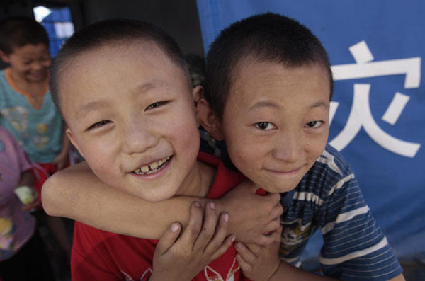  Two boys play in a temporary shelter in landslide-hit Zhouqu county, Northwest China&apos;s Gansu province, Aug 19, 2010. [Xinhua]