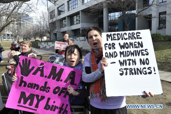 Demonstrators gather outside the National Press Club in Canberra, capital of Australia, on Aug. 19, 2010, as Australian Prime Minister Julia Gillard delivers her speech. Gillard delivered her last formal speech before the general election in Canberra on Thursday. Australia will hold the general election on Aug. 21. [Huang Xiaoyong/Xinhua]