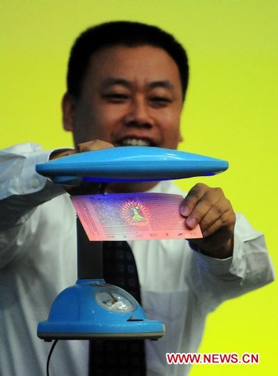 A staff member displays the anti-counterfeit label on the rear of a ticket sample for the Guangzhou Asian Games in Guangzhou, capital of south China's Guangdong Province, on Aug. 18, 2010. The Guangzhou Asian Games Organizing Committee (GAGOC) unveiled the ticket designs of the Games during a press conference on Wednesday. (Xinhua/Liu Dawei)