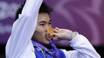 Pisit Poodchalat of Thailand bites the gold medal during the awarding ceremony of the boys' singles final match of badminton at the Singapore 2010 Youth Olympic Games in Singapore, August 19, 2010.