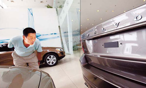 A customer examines a Volvo S90L sedan in Beijing. [China Daily via agencies]