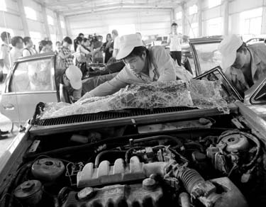 Workers disassemble a 'yellow label' car - those that fail to meet the European No 1 standard for exhaust emissions - in a dismantling plant in Beijing's Shunyi district on Thursday. More than 30,000 'yellow label' vehicles have been scrapped in the capital as of Aug 13. 