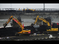 Workers disassemble the damaged carriage off the Baoji-Chengdu Railway in Xiaohan Township of Guanghan city, southwest China's Sichuan Province, Aug. 20, 2010. The railway between Baoji, a city of China's Shaanxi Province, and Chengdu, capital of China's Sichuan Province, was reconnected Friday by an alternative railway though a railway bridge on its Guanghan part was destroyed by floods on Thursday. [Jiang Hongjing/Xinhua]