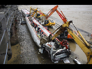 Workers disassemble the damaged carriage off the Baoji-Chengdu Railway in Xiaohan Township of Guanghan city, southwest China's Sichuan Province, Aug. 20, 2010. The railway between Baoji, a city of China's Shaanxi Province, and Chengdu, capital of China's Sichuan Province, was reconnected Friday by an alternative railway though a railway bridge on its Guanghan part was destroyed by floods on Thursday. [Jiang Hongjing/Xinhua]