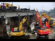 Workers disassemble the damaged carriage off the Baoji-Chengdu Railway in Xiaohan Township of Guanghan city, southwest China's Sichuan Province, Aug. 20, 2010. The railway between Baoji, a city of China's Shaanxi Province, and Chengdu, capital of China's Sichuan Province, was reconnected Friday by an alternative railway though a railway bridge on its Guanghan part was destroyed by floods on Thursday. [Jiang Hongjing/Xinhua]