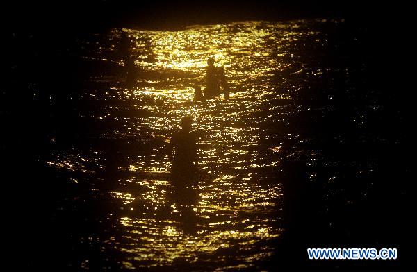 Iranian people enjoy swimming at seaside near the Bushehr nuclear power plant in southern Iran, Aug. 20, 2010. Nuclear fuel is going be loaded to Bushehr nuclear power plant the first one in Iran on Aug. 21. Bushehr nuclear power plant draws great attention after the U.S. Chairman of the Joint Chiefs of Staff Mike Mullen said earlier this month that the United States has a plan in place to attack Iran, if it is necessary.[Ahmad Halabisaz/Xinhua]