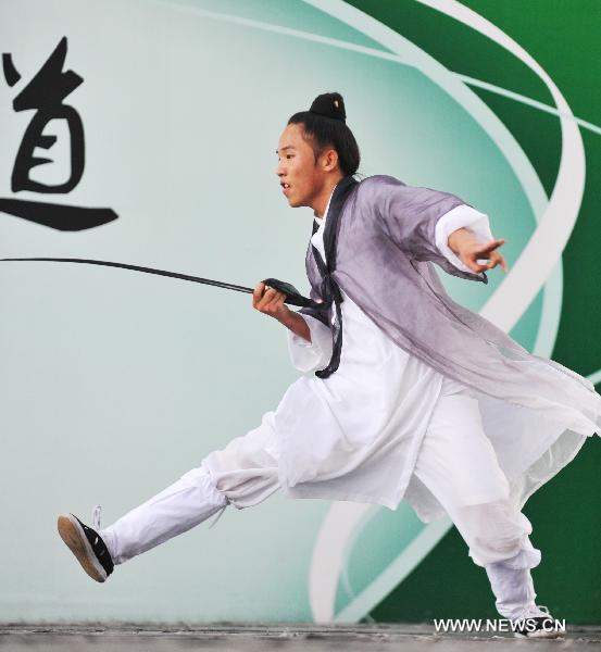 A member of the kungfu team under the Wudang Taoist Association performs Wudang Taiji kungfu at the World Expo Park, in Shanghai, east China, Aug. 12, 2010. Two distinctive martial arts performances were respectively staged by monks from the Shaolin Temple and members of the kungfu team under the Wudang Taoist Association in the World Expo Park in recent days.[Ding Haitao/Xinhua]