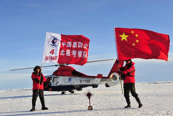 Wu Jun (R), the crew leader of the fourth Chinese scientific expedition team, and Yu Xingguang, a scientist, wave the flags at the North Pole, Aug. 20, 2010. The Chinese fourth expedition team arrived at the North Pole on 15:38 p.m. (0738 GMT) Friday, which is the northernmost location ever reached by Chinese scientific expeditions. [Zhang Jiansong/Xinhua]