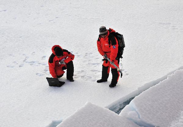 Two members of the fourth Chinese scientific expedition team measure spectral albedo of ice surface at 88 degrees north latitude, Aug. 20, 2010. The Chinese fourth expedition team arrived at 88 degrees and 22 minutes north latitude on Friday, which is the highest latitude ever reached by Chinese ships.[Zhang Jiansong/Xinhua]