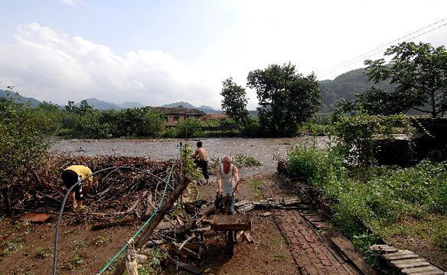 Villagers clean a yard in Tuanjie Village, Kuandian Man Autonomous County of Dandong City, northeast China's Liaoning Province, Aug. 21, 2010.
