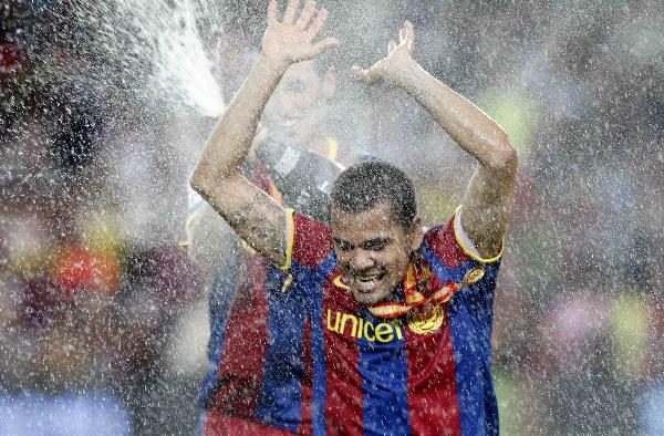 Barcelona&apos;s Sergio Busquets sprays champagne on his teammate Dani Alves after they beat Sevilla to win the Spanish Super Cup at Nou Camp stadium in Barcelona August 21, 2010. 