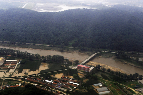 An aerial photo shows houses are inundated in flood waters in Dandong, northeast China&apos;s Liaoning province on August 22, 2010. About 99,000 people have been evacuated and at least four killed as heavy rains triggered landslides and breached banks of the Yalu River, inundating houses and farmland in China and DPRK.[Xinhua]