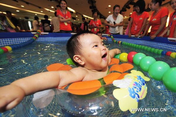 A six-month-old baby swims in the final of a swimming competition for babies of 0-3 years of age in Hangzhou, capital of east China&apos;s Zhejiang Province, Aug. 22, 2010. [Xinhua]