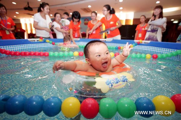 A baby reacts in the final of a swimming competition for babies of 0-3 years of age in Hangzhou, capital of east China&apos;s Zhejiang Province, Aug. 22, 2010. [Xinhua]