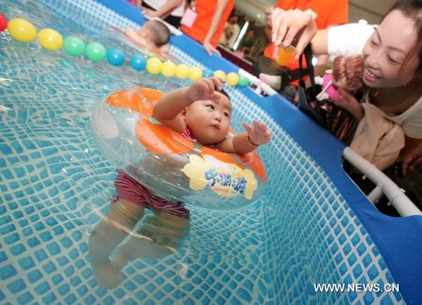 A baby reacts in the final of a swimming competition for babies of 0-3 years of age in Hangzhou, capital of east China&apos;s Zhejiang Province, Aug. 22, 2010. [Xinhua]